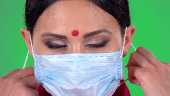 Portrait of Beautiful Indian Girl Is Looking at the Camera and Takes Off Her Protective Medical Mask