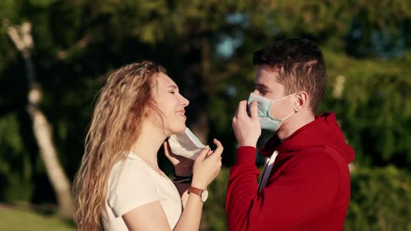 Young Family Couple in Love Medical Protective Masks in City Sunset