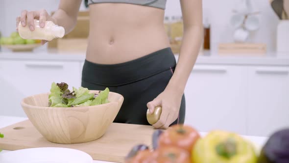 Young Asian woman making salad healthy use organic vegetables lots of nutrition.