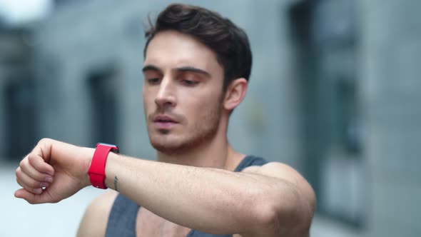 Closeup Male Athlete Using Smart Clock Outside. Fit Man Setting Smart Watch