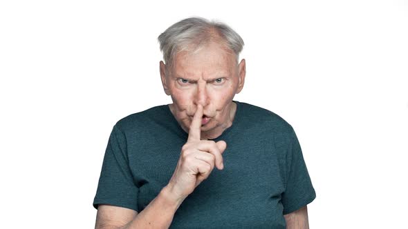 Portrait of Angry Old Aged Man 80s in Basic Tshirt Posing with Strict Gaze and Asking Keep Silence