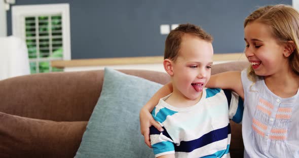 Smiling boy and girl sitting on sofa