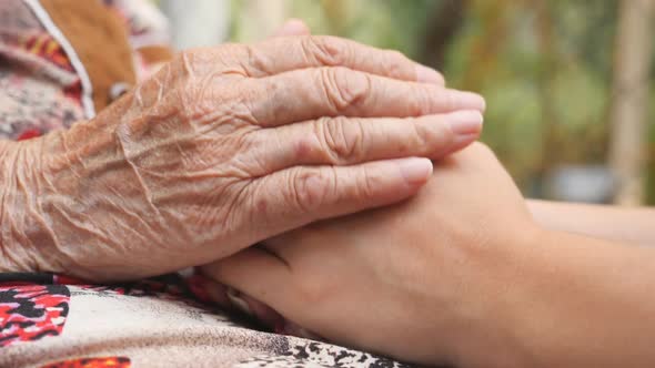 Hand of Old Women Stroking Young Female Arms Outdoor