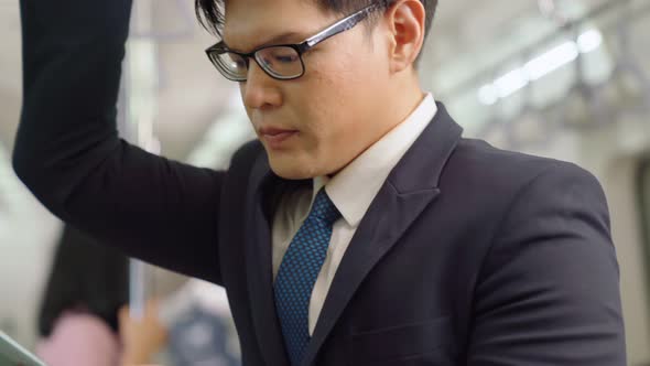 Businessman Using Mobile Phone on Public Train