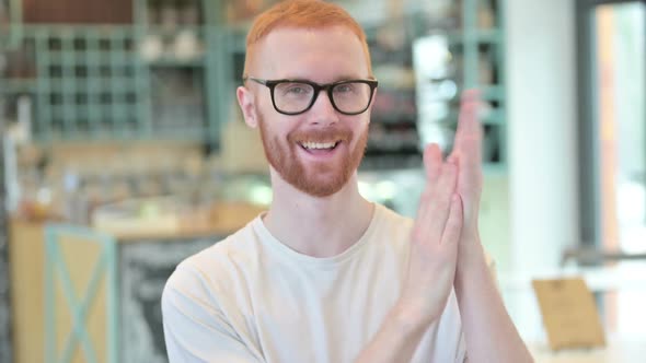 Portrait of Cheering Redhead Man Clapping