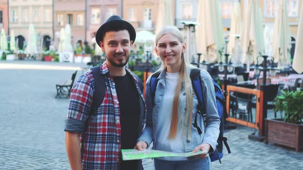 Zoom Shot of Tourist Couple Holding Map and Smiling to the Camera