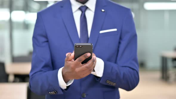 African Businessman Using Smartphone at Work