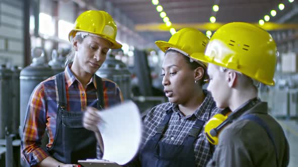 African Factory Engineer Speaking with Employees