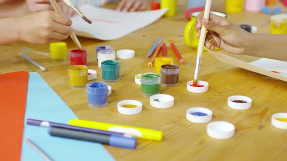 Close Up of Hands of Kids Painting with Gouache alt