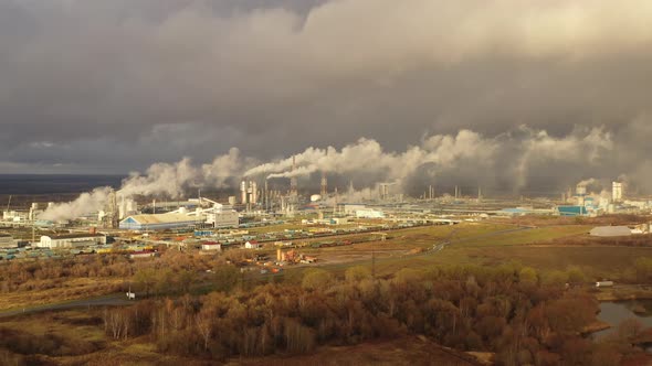 White Smoke Comes Out of a Large Number of Tall Chimneys of Chemical Plants Against the Backdrop of