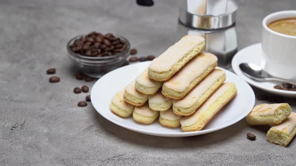 Italian Savoiardi Ladyfingers Biscuits and Cup of Coffee on Concrete Background