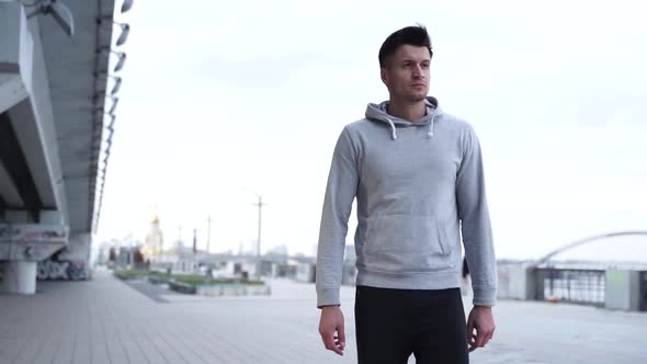 Man is Walking After Jogging. Close Up of Modern Sports Man Wearing Grey Jacket 