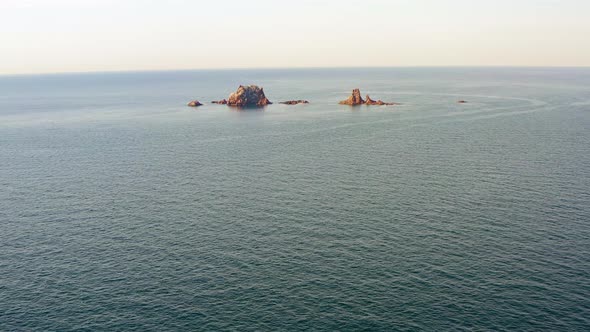 Beautiful Vertical Rocks Sticking Out of the Water at Dawn