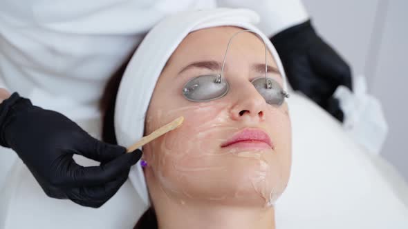 Professional Skincare in Cosmetology Clinic Aesthetician is Applying Moisturizing Mask or Peeling