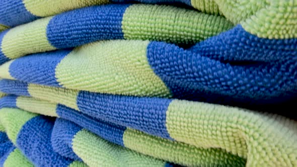 A stack of folded blue and green striped bath beach towels at the local swimming pool and fitness ce