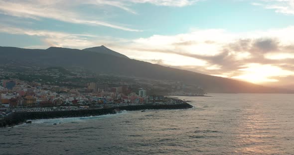 Aerial Panorama of Puerto De La Cruz Resorts and Pools Surrounded By Sea Waves on Sunset Tenerife