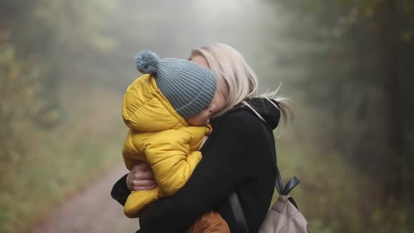 mother with son on forest in autumn season