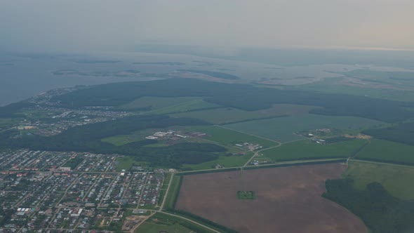 Aerial View at Coastal Town Fields and Sea in Mist From the Plane Window