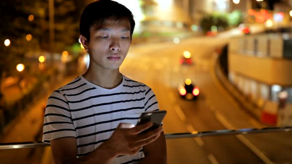 Young man using smart phone in city