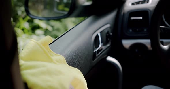 Car Cleaning Concept. The Man's Hand Cleans the Car From the Dust Using a Yellow Cloth.