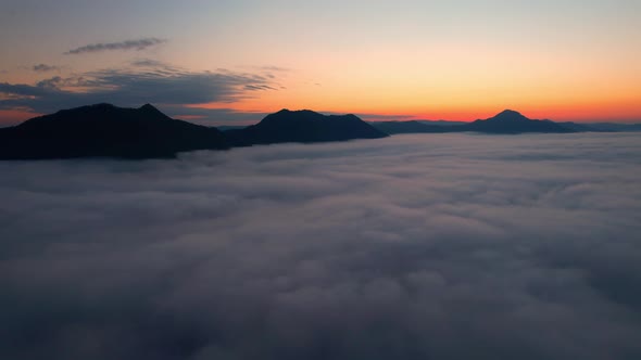4K Drone Flying through the clouds at dusk or dawn. Aerial top cloudscape view from drone