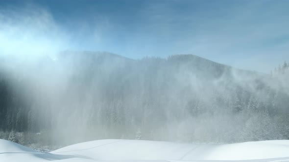 Artificial Snow From Snow Cannon Falls on Ski Resort Sunny Day