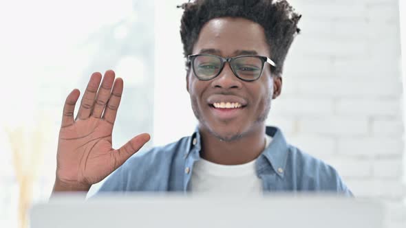 Portrait of Young African Man Doing Video Chat on Laptop