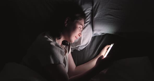 Woman Use Smart Phone And Lying On Bed At Night. Turn Off. High angle