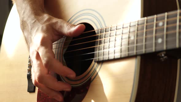 The Musician Plays a Yellow Acoustic Guitar, Close-up at the Guitar Deck