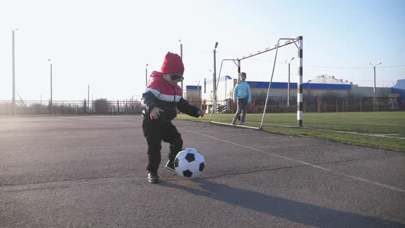 Little Children Playing with Soccer Ball at Near the Football Field. Two Cute Young Brother