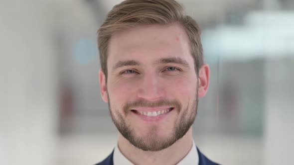 Close Up of Face of Young Businessman Smiling at the Camera