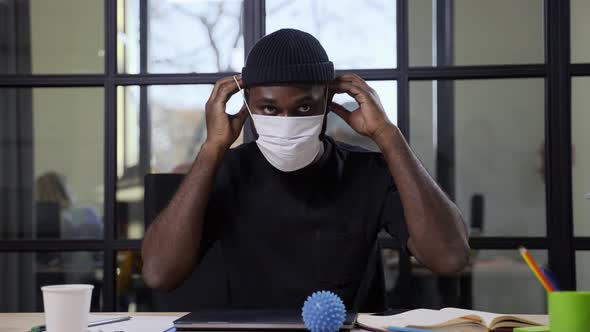 Darkskinned Male Putting on Face Mask on Camera