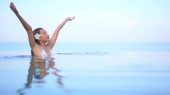 Young asian woman enjoy around outdoor swimming pool for leisure