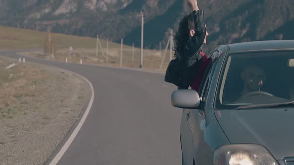 Lady with Dark Hair Feels Happy and Relaxed Sitting in Car