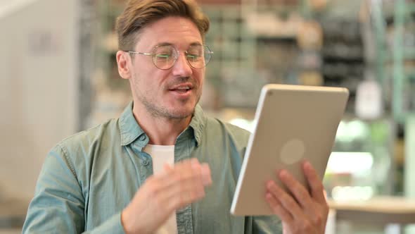 Portrait of Middle Aged Man Doing Video Chat on Digital Tablet 