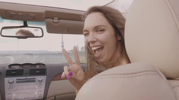 Young beautiful and smiling hipster girl in convertible car