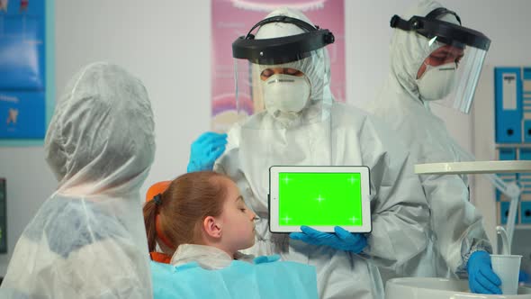 Stomatologist with Coverall Pointing at Mockup Greenscreen Display