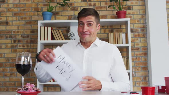 Caucasian man making video call holding handwritten sign making marriage proposal and celebrating ac