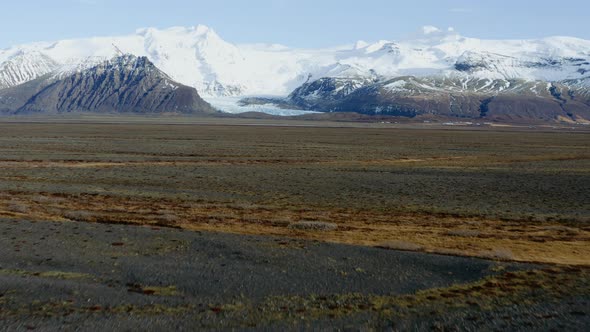 Drone Over Landscape Towards Snow Covered Mountains