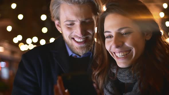 Smiling Beautiful Caucasian Pair Looking at Mobile Phone Discussing Talking in Slowmotion