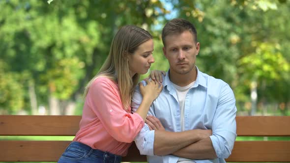 Woman Hugging Offended Man Rejecting Kiss, Reconciliation Attempt, Outdoors