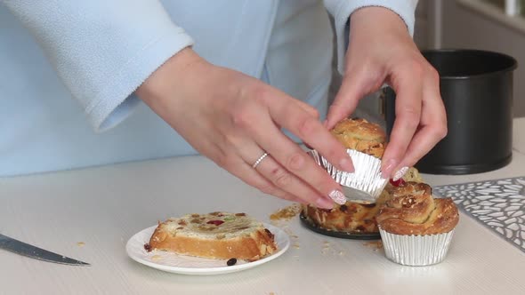 A Woman Demonstrates A Cooked Cruffin With Raisins And Candied Fruit. Medium Plan.