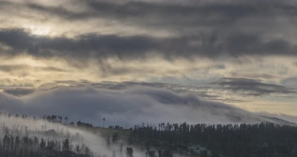 Timelapse of Evening Sun Rays Emerging Through the Cold Foggy Clouds in the Mountains. Sunset