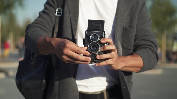 Right To Left Pan Real Time Shot of a Young Asian Man Taking a Picture on an Old Camera. Tourist in