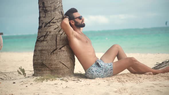 Man On Vacation. Tanned Man Relaxing Vacation Caribbean Tropical Beach. Man Lying On Tropical Beach.