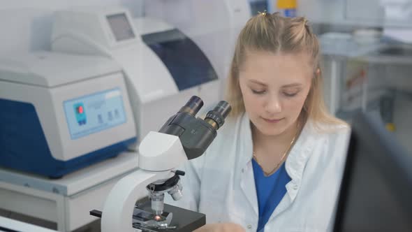 Female Researcher Using Microscope in a Lab