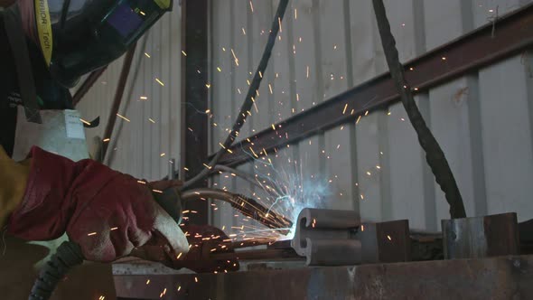 Slow motion of a welder welding construction steel frames