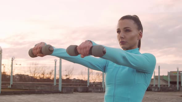 Young, beautiful and sporty woman having evening training outdoor.