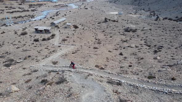 Aerial view of person mountain biking down trail in Manang Nepal