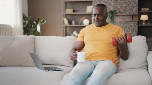 Senior Elderly African American Active Retired Man Male Pensioner Sit on Sofa Doing Weight Lifting